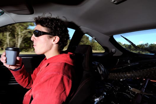 Man driving while drinking coffe
