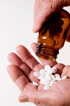 Senior hands pouring out tablets