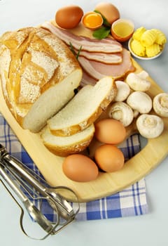 Bread, bacon, eggs and mushrooms ready to be cooked for breakfast.
