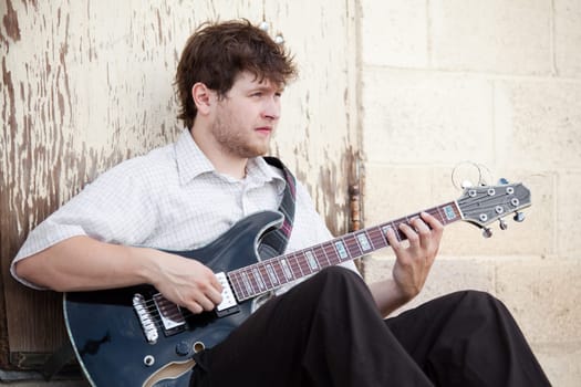 young man playing guitar outdoors