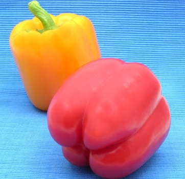 Red and yellow bell pepper against blue background