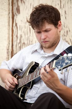 young man playing guitar outdoors
