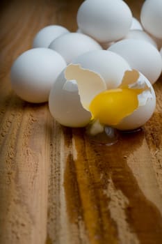 Cracked egg in front of pile of eggs.