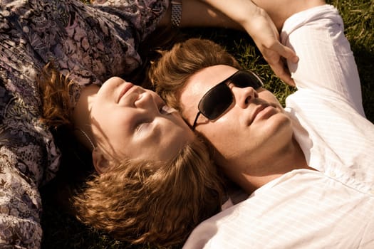 Couple Lying Close On Grassy Ground