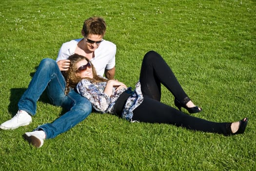 Young Couple Laying On Grass Field