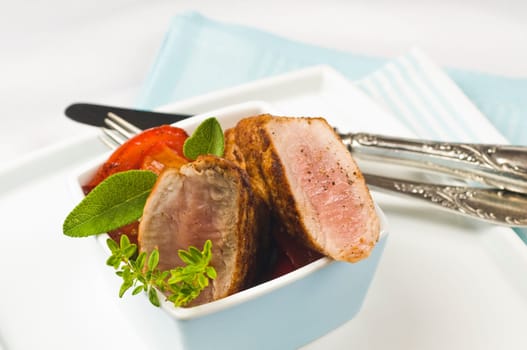 Pork tenderloin,fried in light blue bowl with herbs