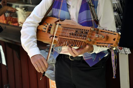 a young man plays on a Swedish nyckelharpa