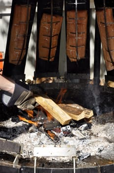 Salmon slices hang over a fire in the smoke