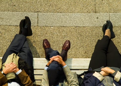 Legs of people on a bench