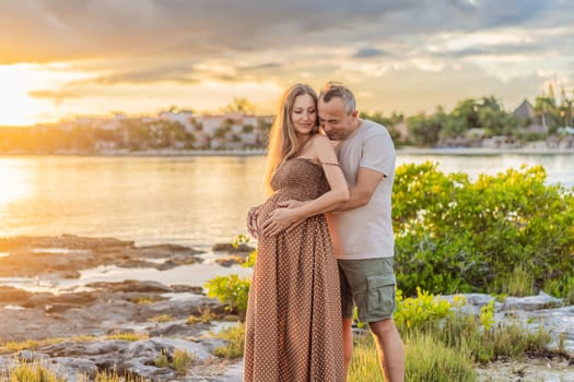 A happy, mature couple over 40, enjoying a leisurely walk on the waterfront On the Sunset, their joy evident as they embrace the journey of pregnancy later in life.