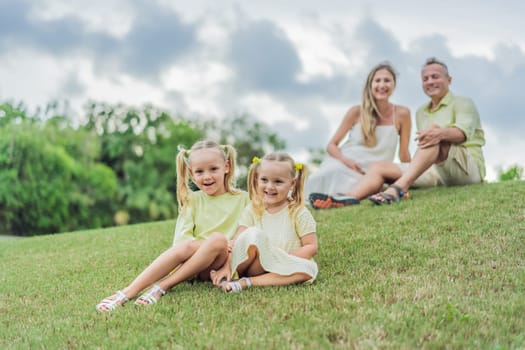 A happy family, two girls, dad, and a pregnant mom, enjoys quality time together on a lush green lawn, creating cherished memories of togetherness.