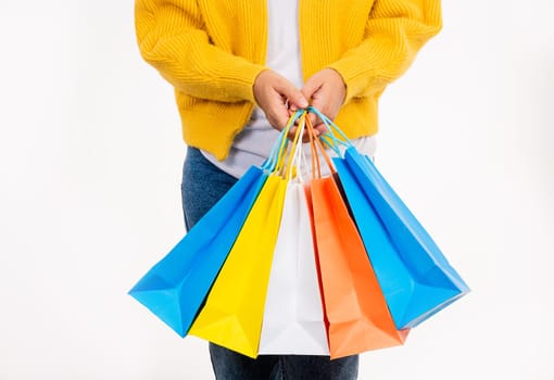 Happy woman hand she wears yellow shirt holding shopping bags multicolor, young female hold many packets within arms isolated on white background, Black Friday sale concept