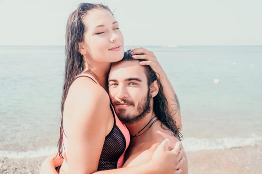 Close up shot of beautiful young caucasian woman with black hair and freckles looking at camera and smiling. Cute woman portrait in a pink bikini posing on a volcanic rock high above the sea