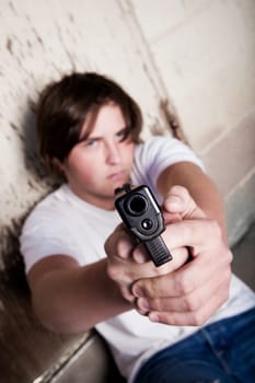 teen male aiming gun at camera