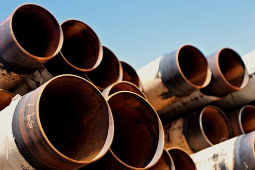 steel pipes stacked under blue sky