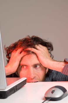 man looking at computer in desperation