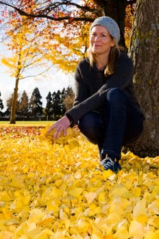 Women throwing yellow autumn leaves