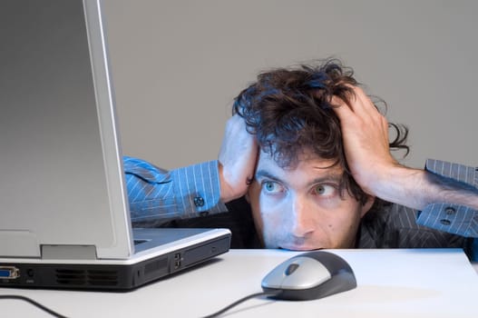 man looking at computer in desperation