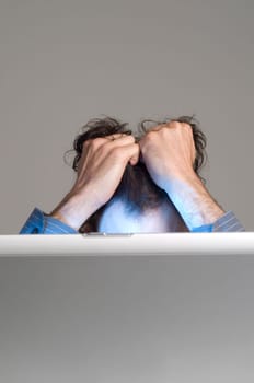 man looking at computer in desperation