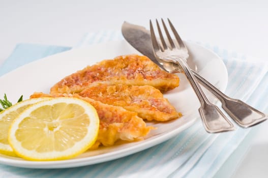 breaded fried mullet fillets on white plate