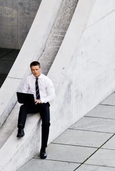 Corporate Man With Laptop Sitting Outside