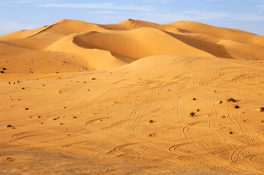 Tire tracks in front of a sand dune in the Sahara desert,Libya