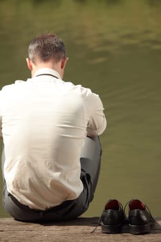 sad businessman at the river