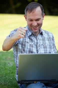 happy man with laptop outdoor