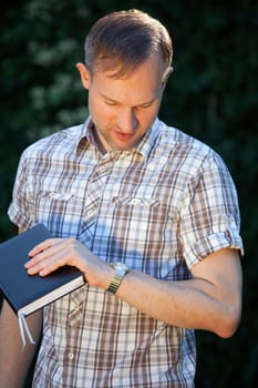 man with diary looking at watch