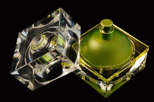 Opened perfume bottle over black