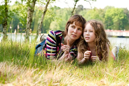 Mother and daugther relaxing in the gras