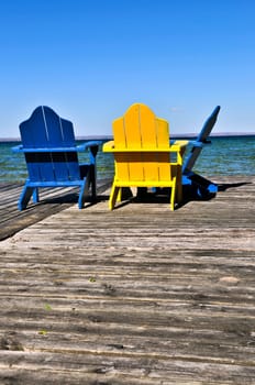 Chairs on wooden dock at lake