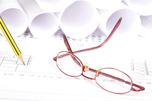 Blueprints, glasses and pencil