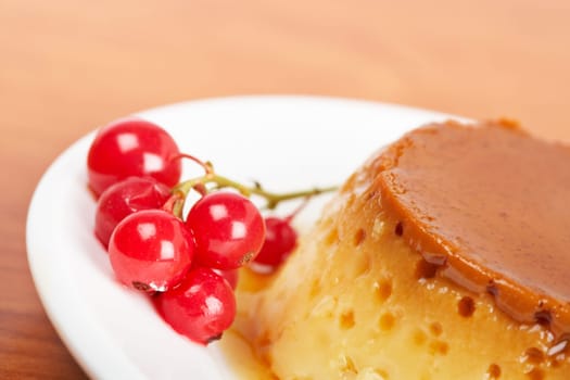 Cream caramel dessert with red currants