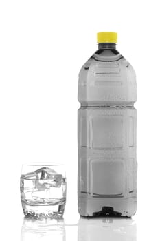 Bottle and glass of mineral water with droplets