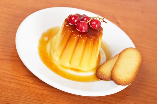 Cream caramel dessert with red currants and cookies