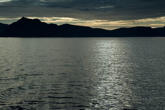 Fjord,backlit mountains
