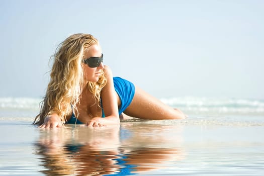 Girl on beach with reflection in water