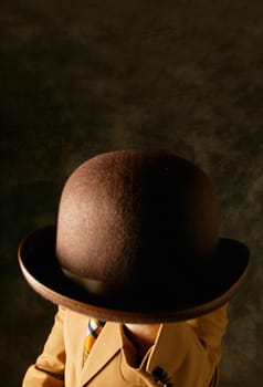 Man holds a hat in front of face