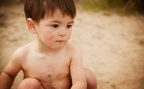 Little boy sitting on beach