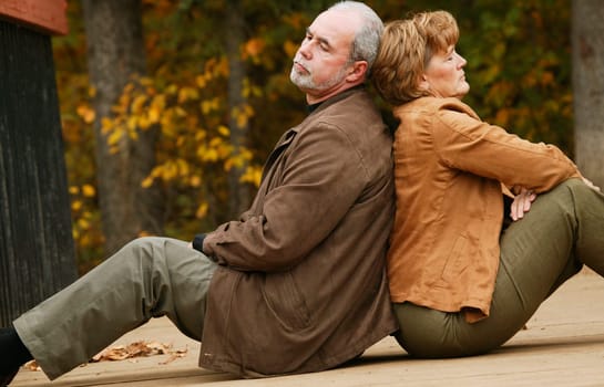 Couple sitting back to back