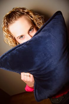 Girl hiding behind a pillow