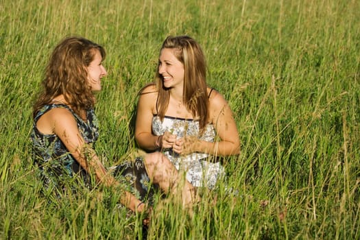 Two young women talking in field