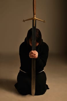 Person kneeling with a sword