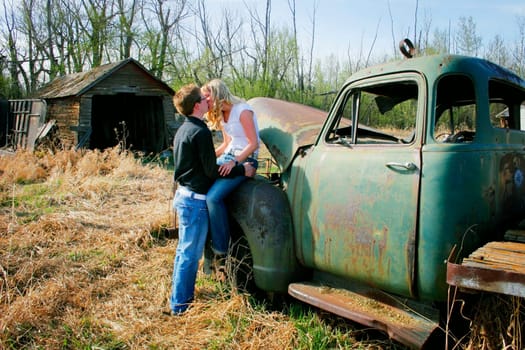 Couple kissing on an old truck