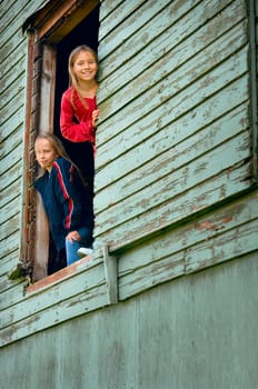Girls looking out of a barn