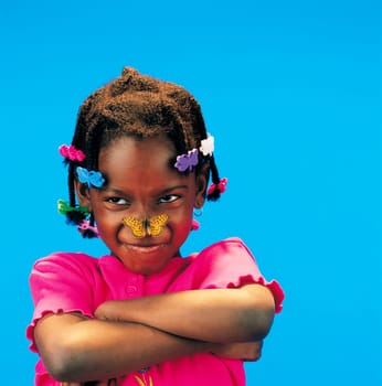 African little girl with arms crossed and a butterfly on her nose