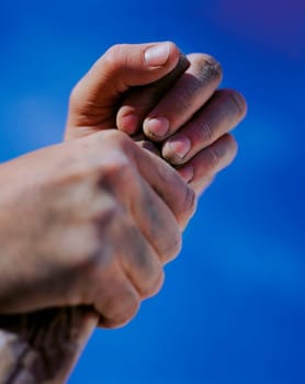 Hands holding stick against blue sky