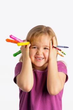 A girl holding crayons and markers