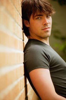Man leans against brick wall